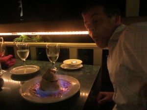 Birthday boy blowing out the candle on his Baked Hawaii